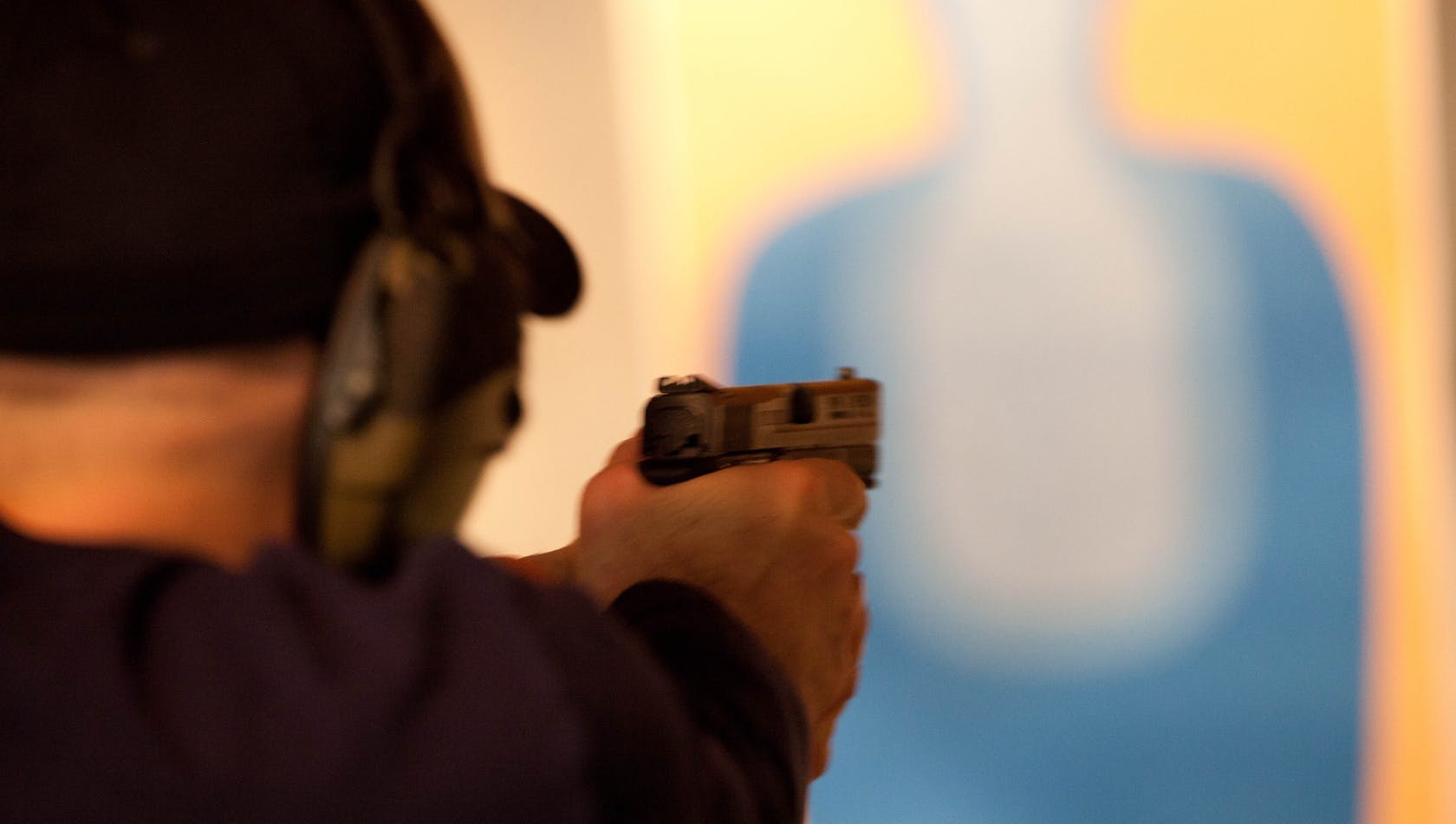 A person aiming a gun at a target