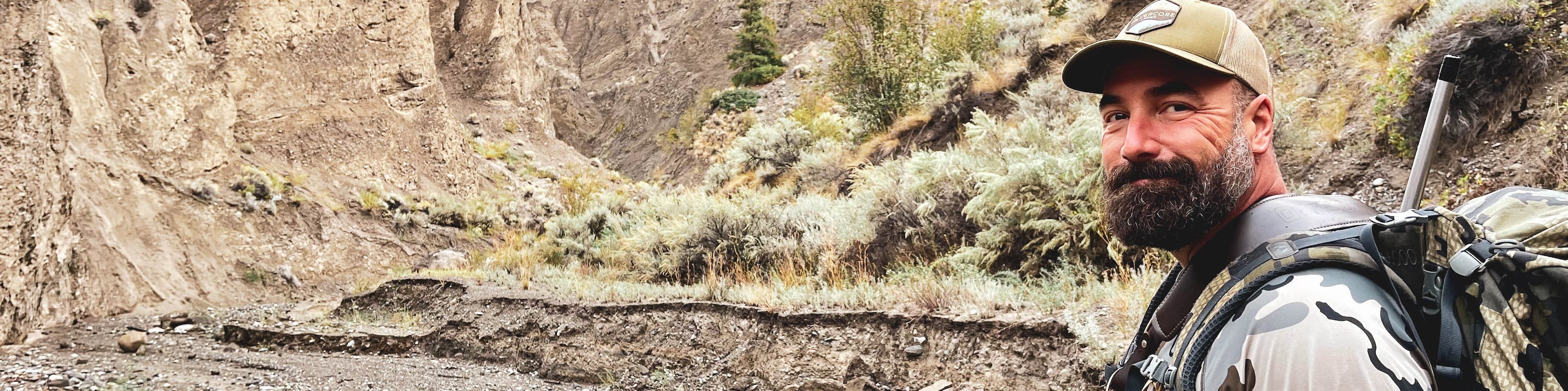 A person wearing camo gear in the mountains