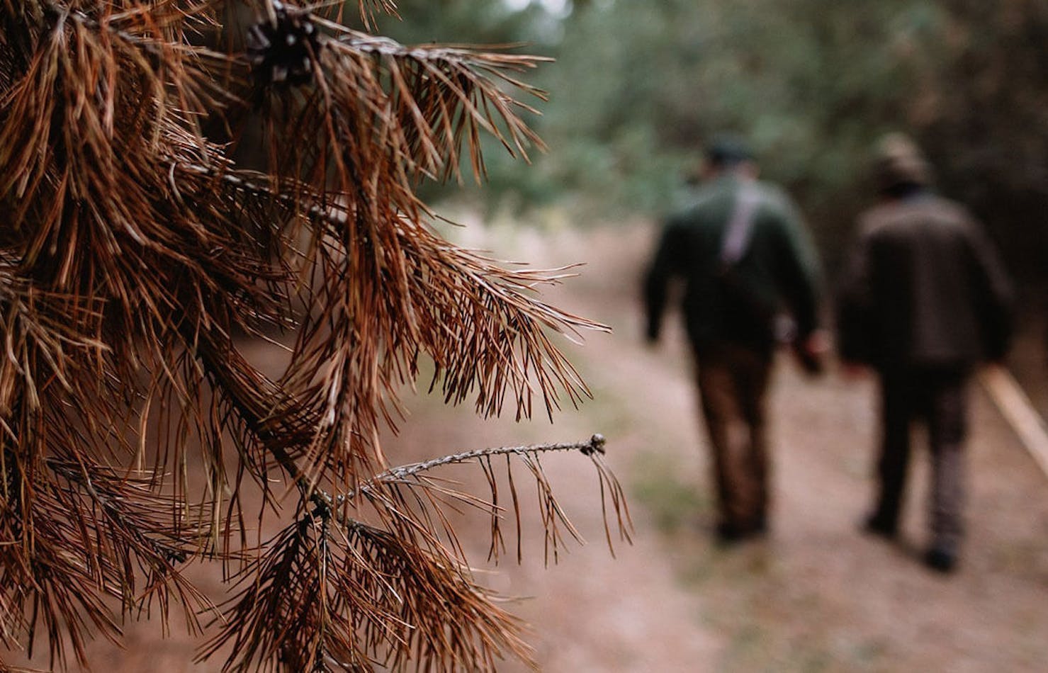 Two hunters on trail blurred